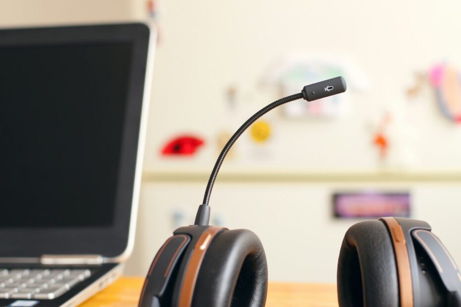 Headset com microfone ao lado de um notebook, pronto para uma cold call de vendas de software